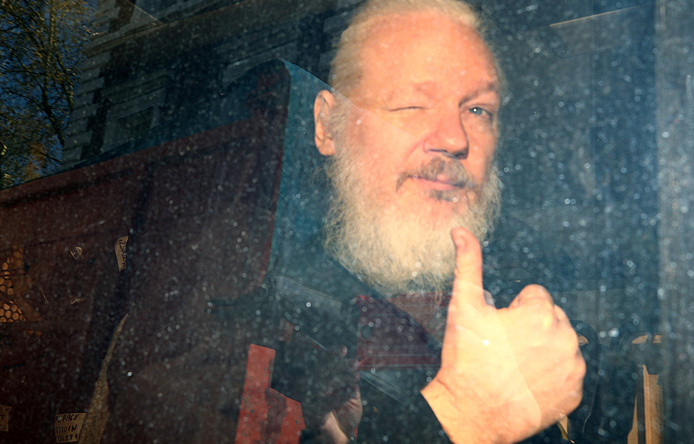 WikiLeaks founder Julian Assange makes a thumbs-up sign after police sensationally dragged him out of the Ecuadoran embassy in London in April 2019.