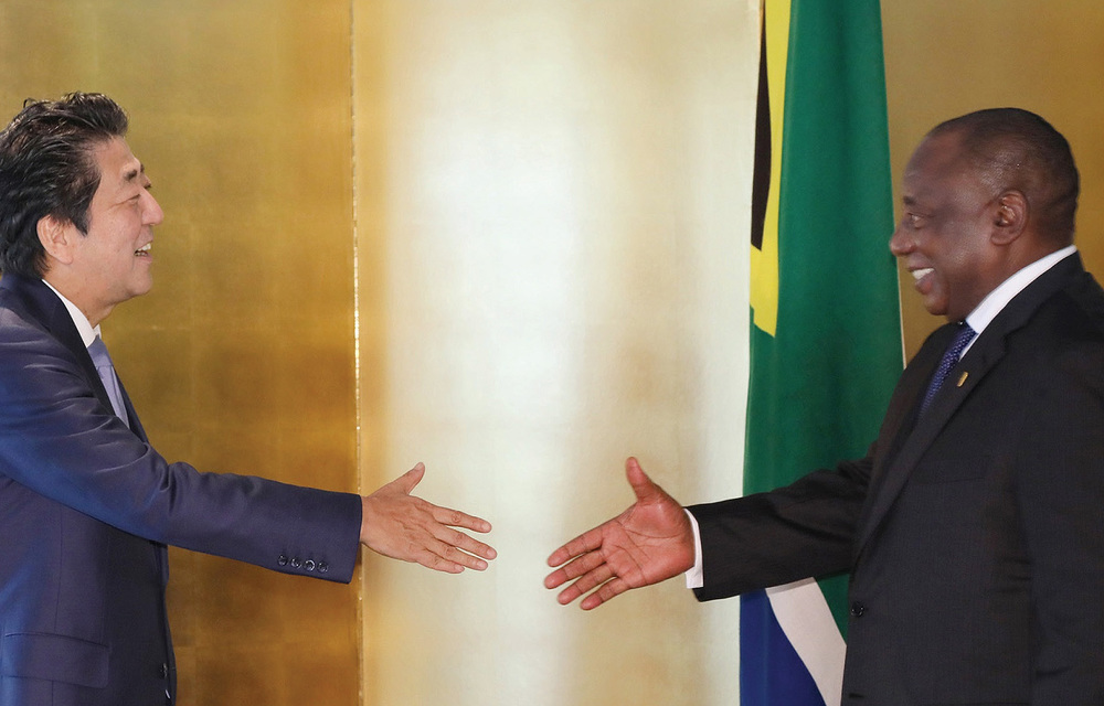 Japanese Prime Minister Abe and South African President Cyril Ramaphosa greet each other at the TICAD 7 conference