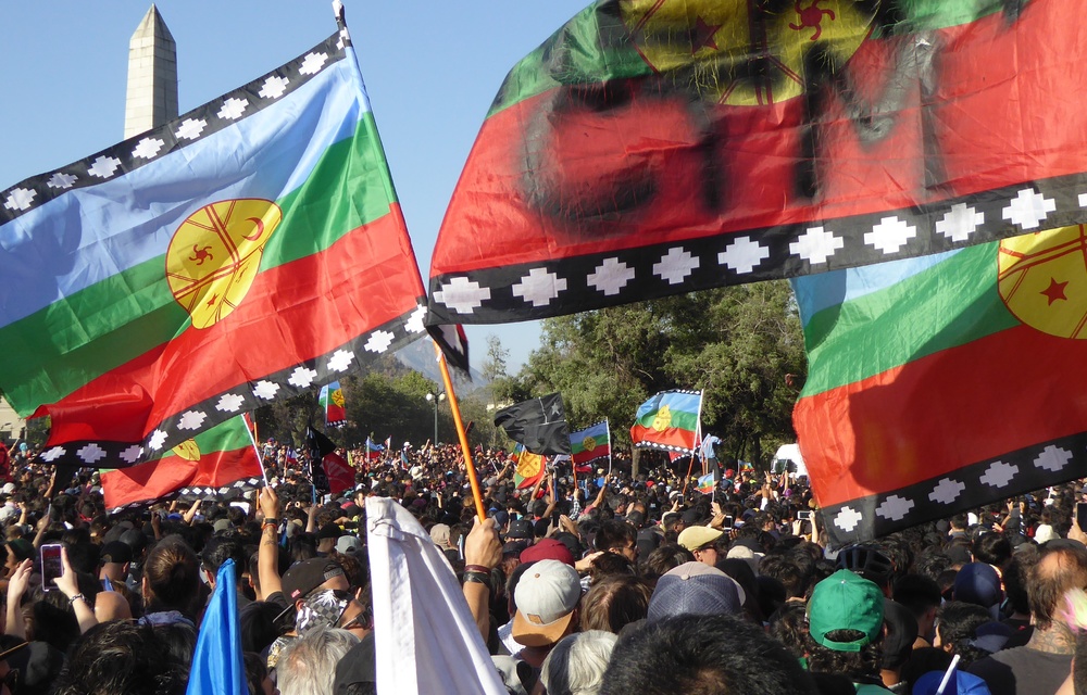 Symbol of resistance: Flags representing the indigenous Mapuche people of Chile are waved at a Inti-Illimani concert and demonstration in Plaza de la Dignidad in Santiago on December.