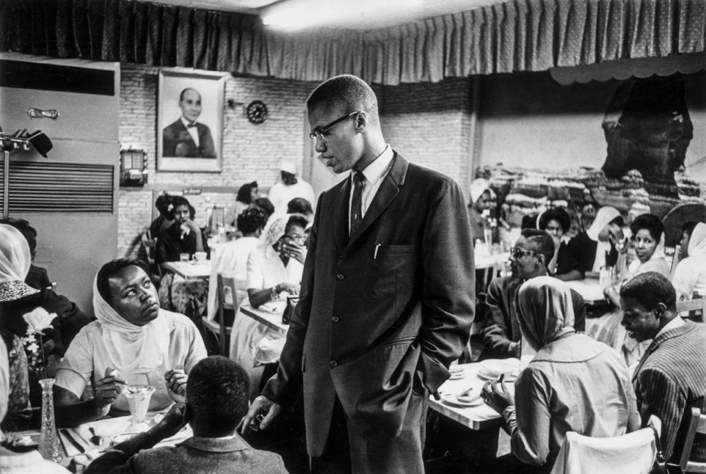 Malcolm talks to a woman inside a black Muslim restaurant in Harlem