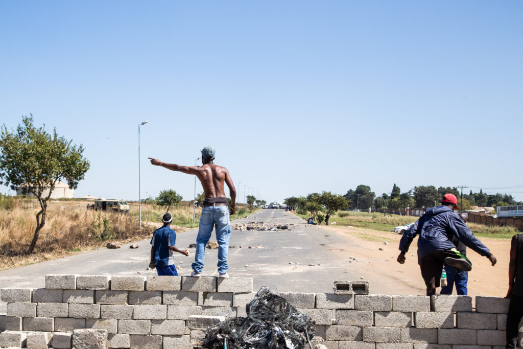 A Topless Protester Makes A Gesture While Standing On Top Of