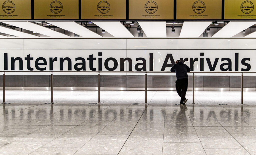 A Man Waits At The Heathrow International Arrival Hall