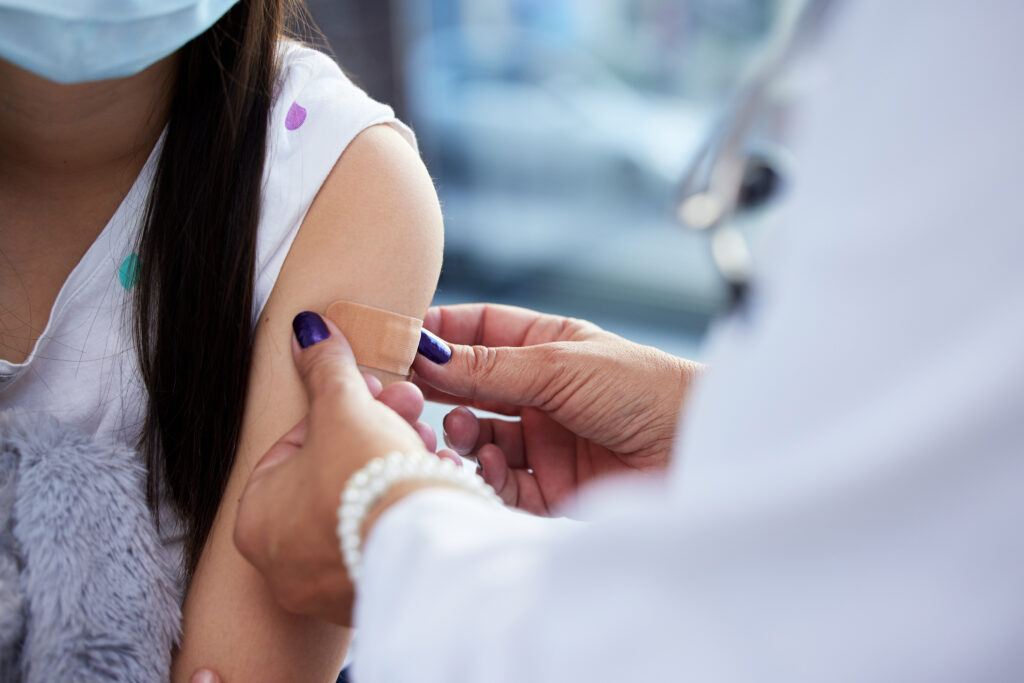 Shot Of A Little Girl Getting A Vaccination In A Hospital