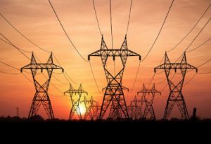 Electricity Pylons At Sunset On Background