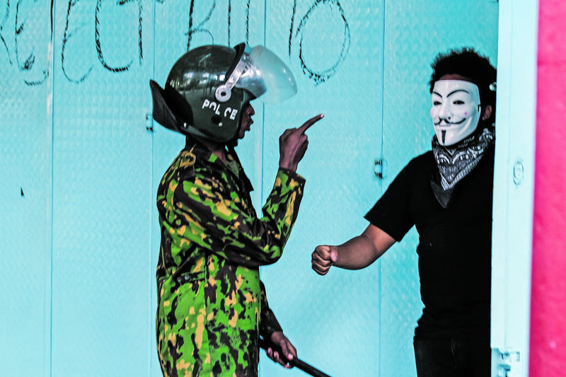 A Policeman Disperses A Demonstrator Taking Part In An Anti